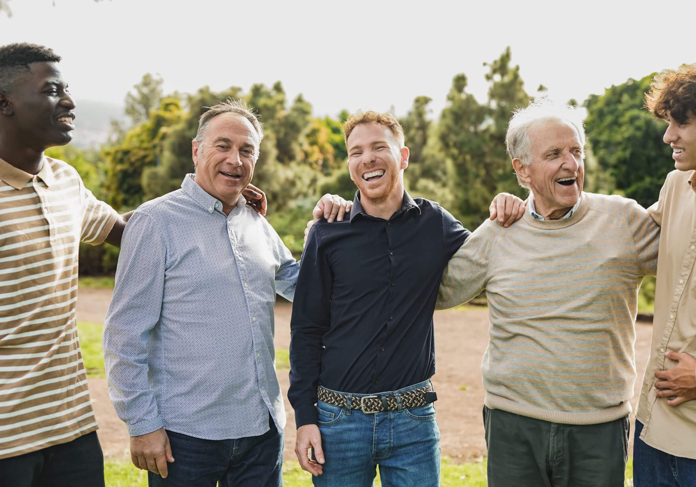 Multi generational men having fun together at city park - Multiracial male friends enjoy day outdoor